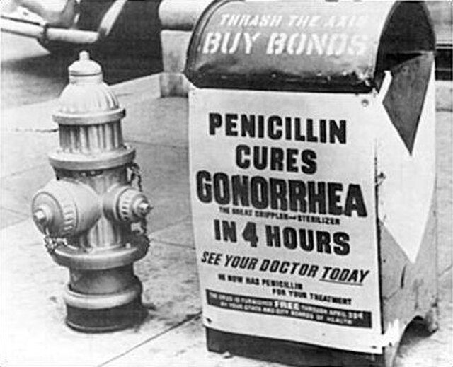 An old black-and-white image of a fire hydrant next to a sign that says 'Penicillin Cures Gonorrhoea in 4 hours'